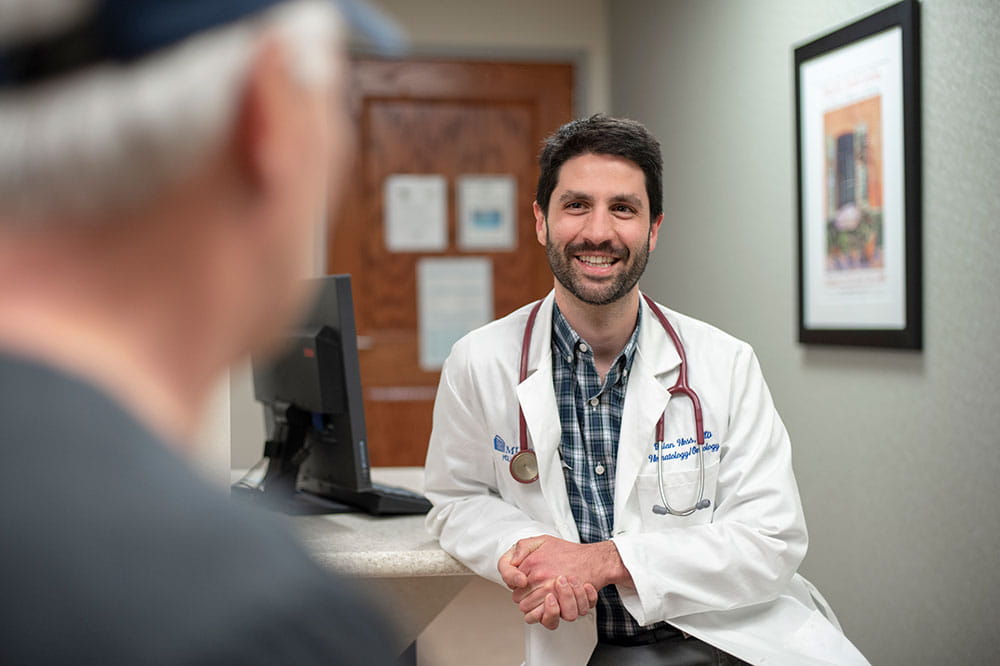 Dr. Brian Hess, part of the Blood & Marrow Transplant Program team, seeing a patient in clinic