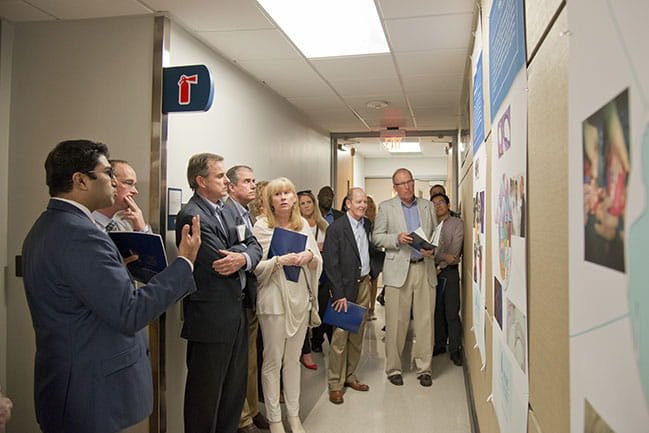 People listen in a hallway as Dr. Nadig speaks 