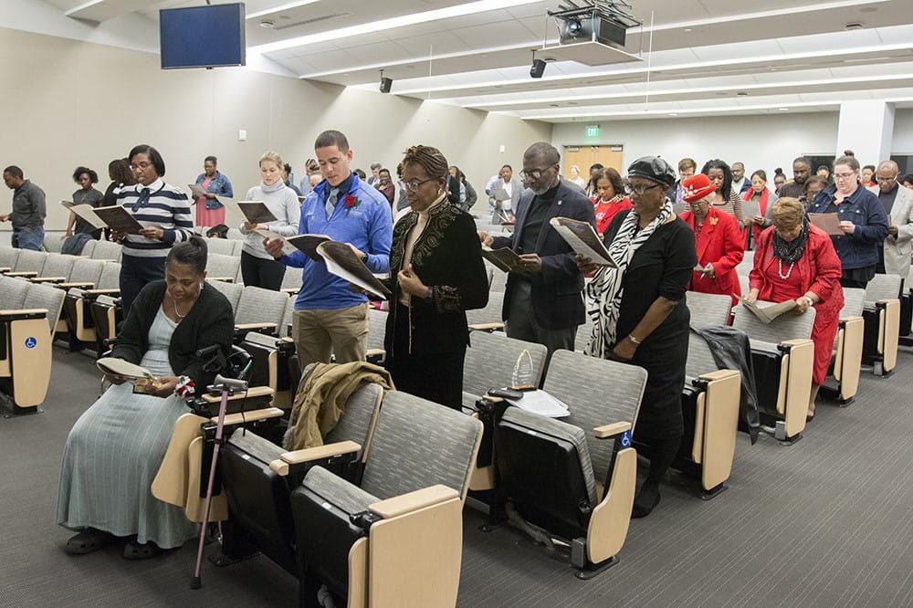 Audience members read a pledge.