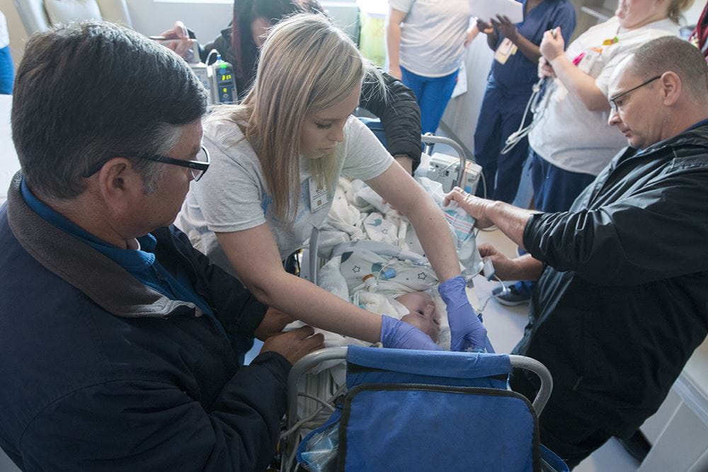 nurses work around small baby