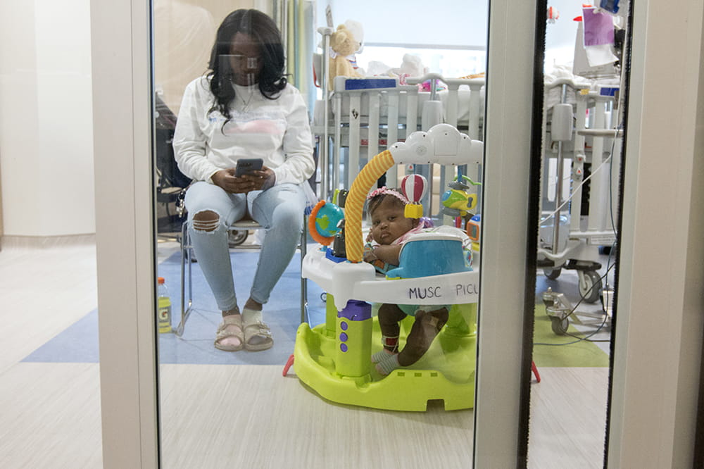 Mya in a baby activity center in her new room